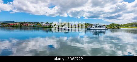 Grüne Bucht von St. John`s, Antigua und Barbuda. Panoramablick auf die Hafenbucht mit Booten und Spiegelung der Wolken im Wasser. Stockfoto